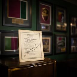 Signed football programme and framed entertainment memorabilia in a display room