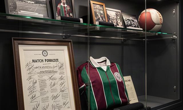Signed sports memorabilia and framed match programme in a secure display room