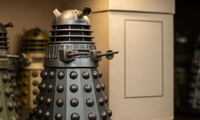 Vintage Doctor Who Dalek toy displayed beside its original box on a collector's shelf